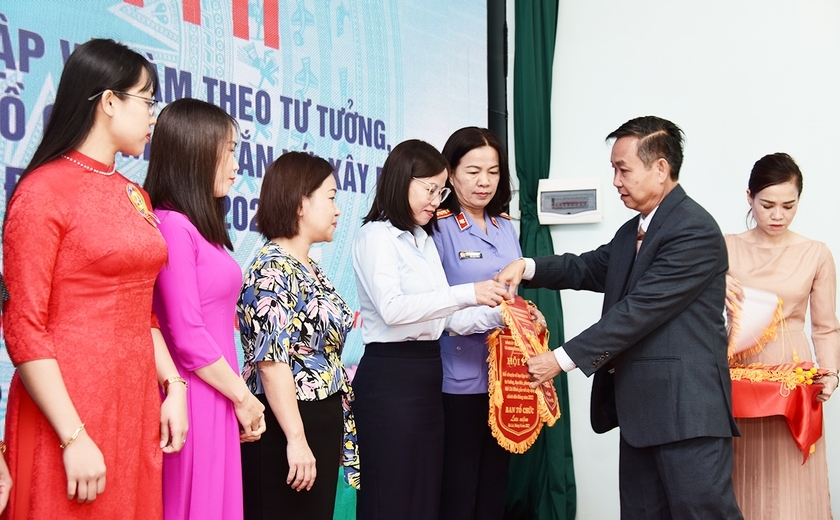 Ông Huỳnh Tấn Đoan-Phó Bí thư Đảng ủy Khối các Cơ quan và Doanh nghiệp tỉnh tặng cờ lưu niệm cho đại diện các tổ chức cơ sở Đảng có thí sinh tham gia Hội thi kể chuyện về học tập và làm theo tư tưởng, đạo đức, phong cách Hồ Chí Minh gắn với xây dựng, chỉnh đốn Đảng. Ảnh: Đức Thụy