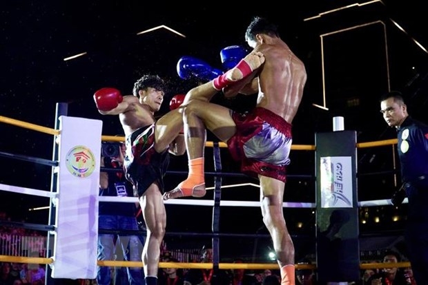 Võ sỹ Nguyễn Trần Duy Nhất - găng đỏ - trong trận tranh đai vô địch IPCC hạng 60kg Nam với võ sỹ người Thái Lan Chaiwat Sungnoi - găng xanh. (Ảnh: Thanh Vũ/TTXVN) ảnh 1