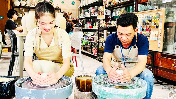 Anh Dương Minh Tâm hướng dẫn cách làm ly gốm cho một bạn trẻ tham gia lớp trải nghiệm tại Vườn Nhà Gốm.