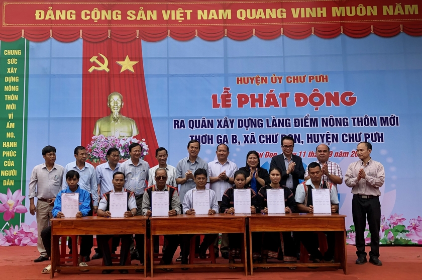 Lãnh đạo hệ thống chính trị làng Thơ Ga B ký cam kết với quyết tâm đoàn kết, đồng lòng xây dựng thành công mô hình điểm làng NTM trong đồng bào dân tộc thiểu số. Ảnh: Lê Nam ảnh 2