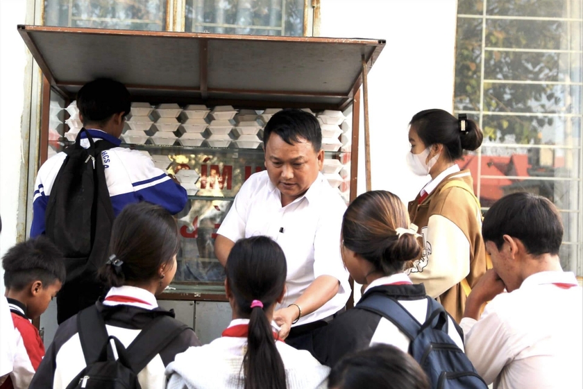 Thầy giáo Vũ Văn Tùng tặng đồ ăn sáng cho học sinh khó khăn. Ảnh: M.N