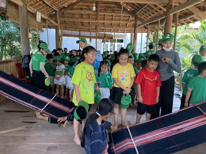 Các em học sinh thích thú khám phá nghề dệt thổ cẩm truyền thống tại homestay A Ngưi (làng Kgiang, xã Kông Lơng Khơng, huyện Kbang). Ảnh: A Ngưi