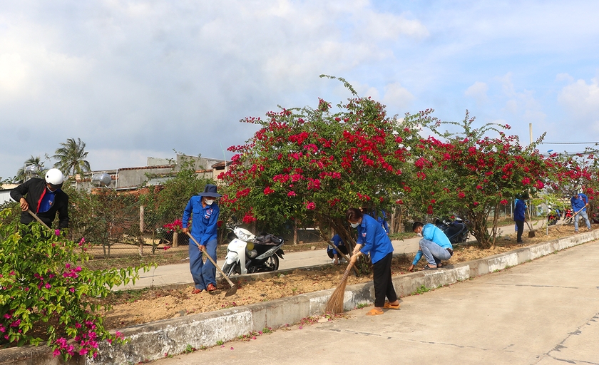 Đoàn viên, thanh niên xã Xuân An (thị xã An Khê) chăm sóc cây hoa và quét dọn vệ sinh đường. Ảnh: A.P