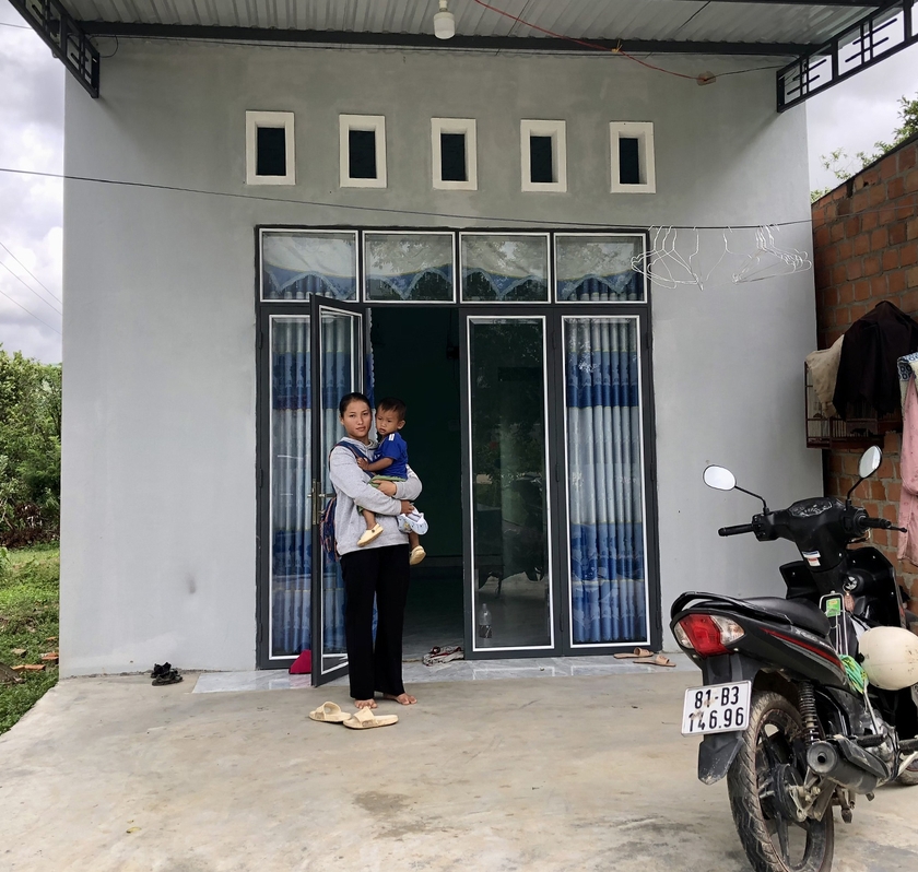 Chị Rơ Lan Nhi (làng Tuêk, xã Đăk Tơ Ver) bên ngôi nhà mới được Nhà nước hỗ trợ xây dựng. Ảnh: L.N
