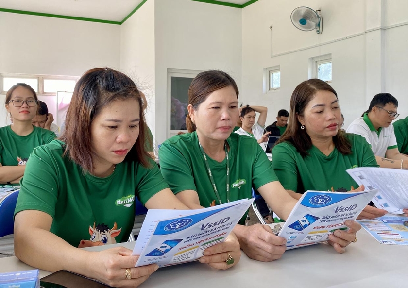 Các đoàn viên, người lao động của Công ty cổ phần Chăn nuôi Bò thịt-Bò sữa Cao Nguyên đọc các thông tin về BHXH, BHYT thông qua các tờ rơi. Ảnh: Hà Duy