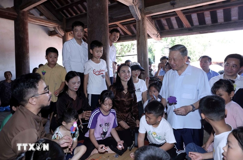 Chủ tịch nước Tô Lâm thăm hỏi thiếu nhi trải nghiệm làm tò he truyền thống tại đình Mông Phụ, làng cổ Đường Lâm. (Ảnh: Nhan Sáng/TTXVN)