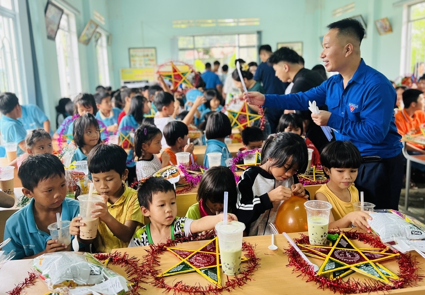 Trẻ em mồ côi được thưởng thức bánh Trung thu và trà sữa. Ảnh: Đinh Yến