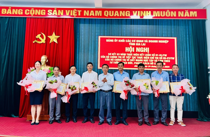 Phó Bí thư Đảng ủy Khối Huỳnh Tấn Đoan (ở giữa) tặng giấy khen các cá nhân có thành tích trong học tập và làm theo Bác. Ảnh: M.N